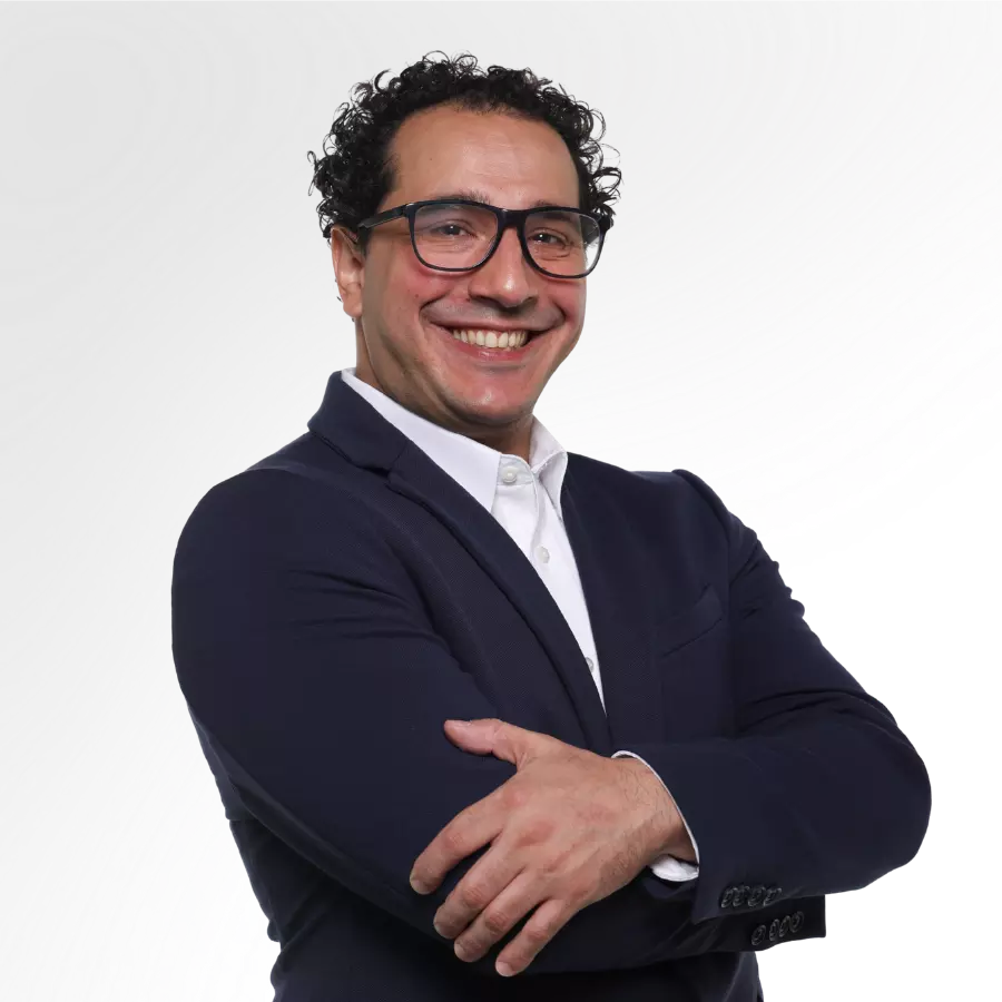 Hombre sonriente con traje y gafas, brazos cruzados