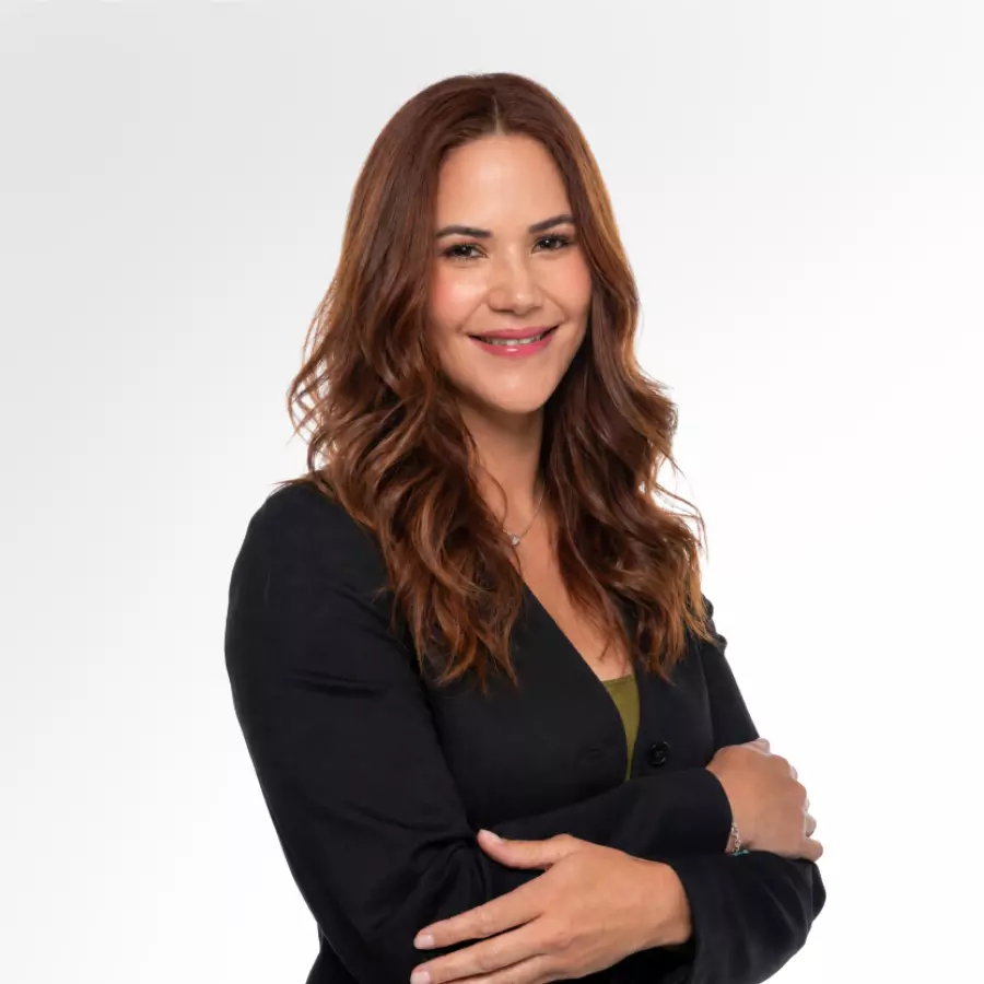Mujer sonriente con blazer negro sobre fondo blanco