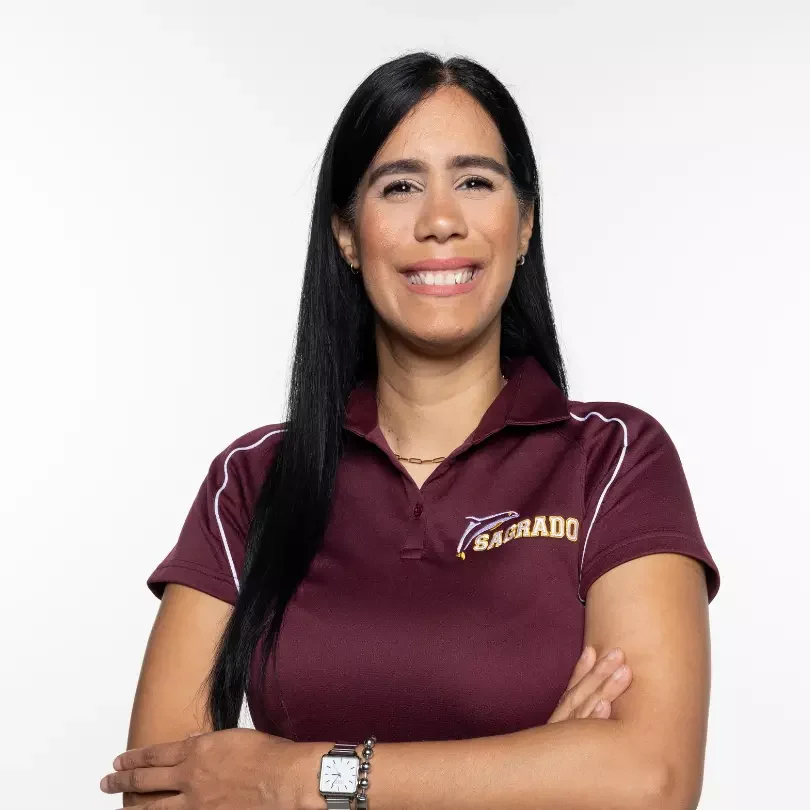 Mujer sonriente con polo granate y brazos cruzados