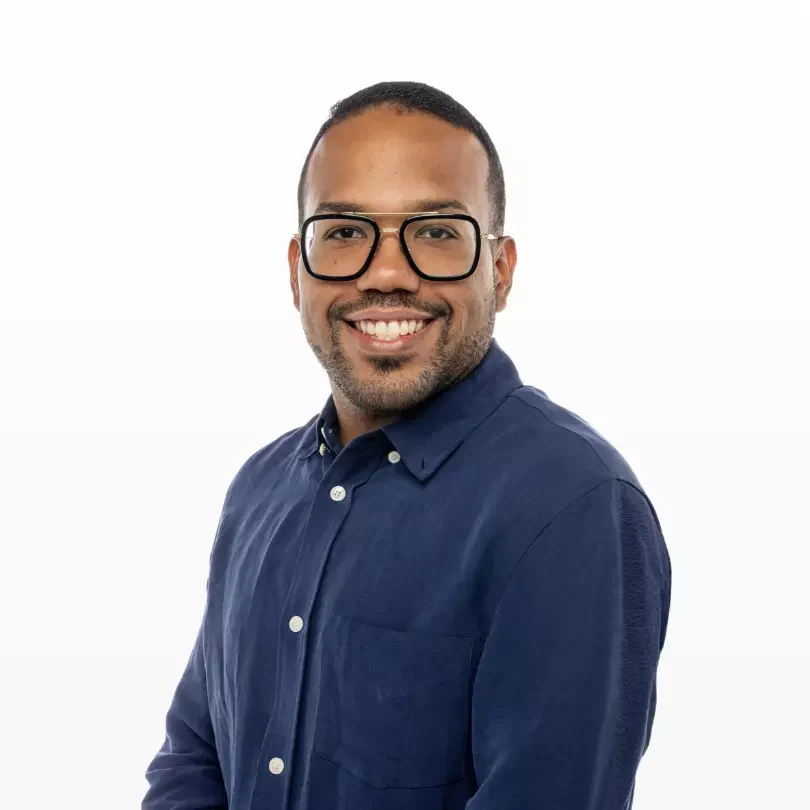 Hombre sonriente con gafas y camisa azul