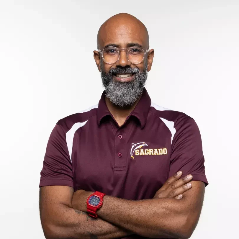 Hombre sonriente con polo granate y gafas