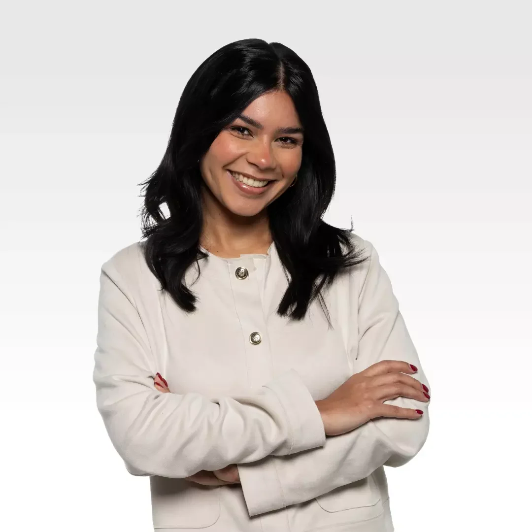 Smiling woman in white jacket with arms crossed