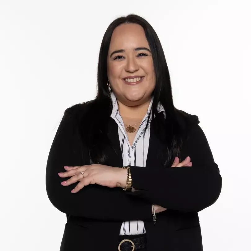 Mujer sonriente con brazos cruzados y traje negro