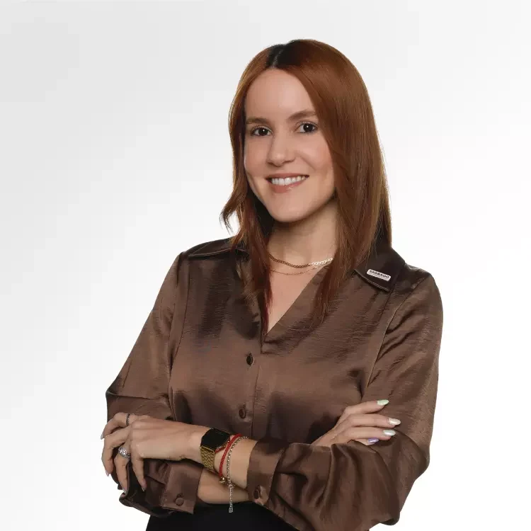 Mujer pelirroja sonriente con brazos cruzados