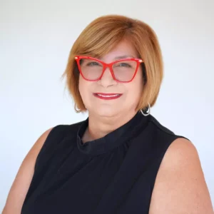 Mujer sonriente con gafas rojas y fondo claro